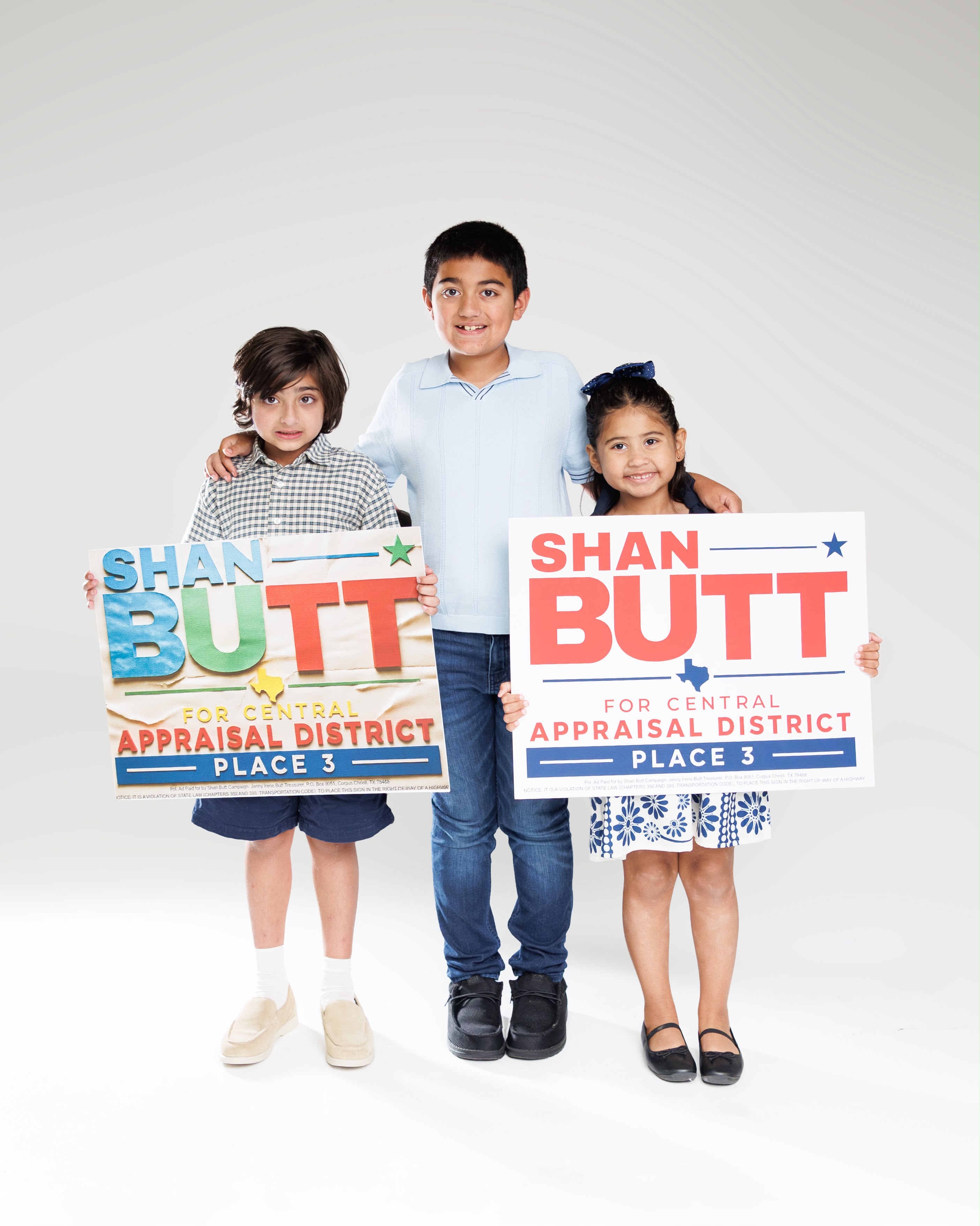 Shan’s three children together holding Place 3 campaign signs